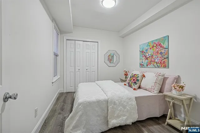 a bedroom with a bed and a painting on the wall