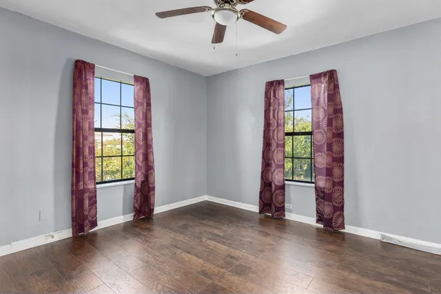 a view of an empty room with window hardwood floor and cabinet