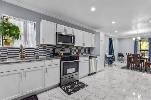 a kitchen with stainless steel appliances a sink stove and cabinets