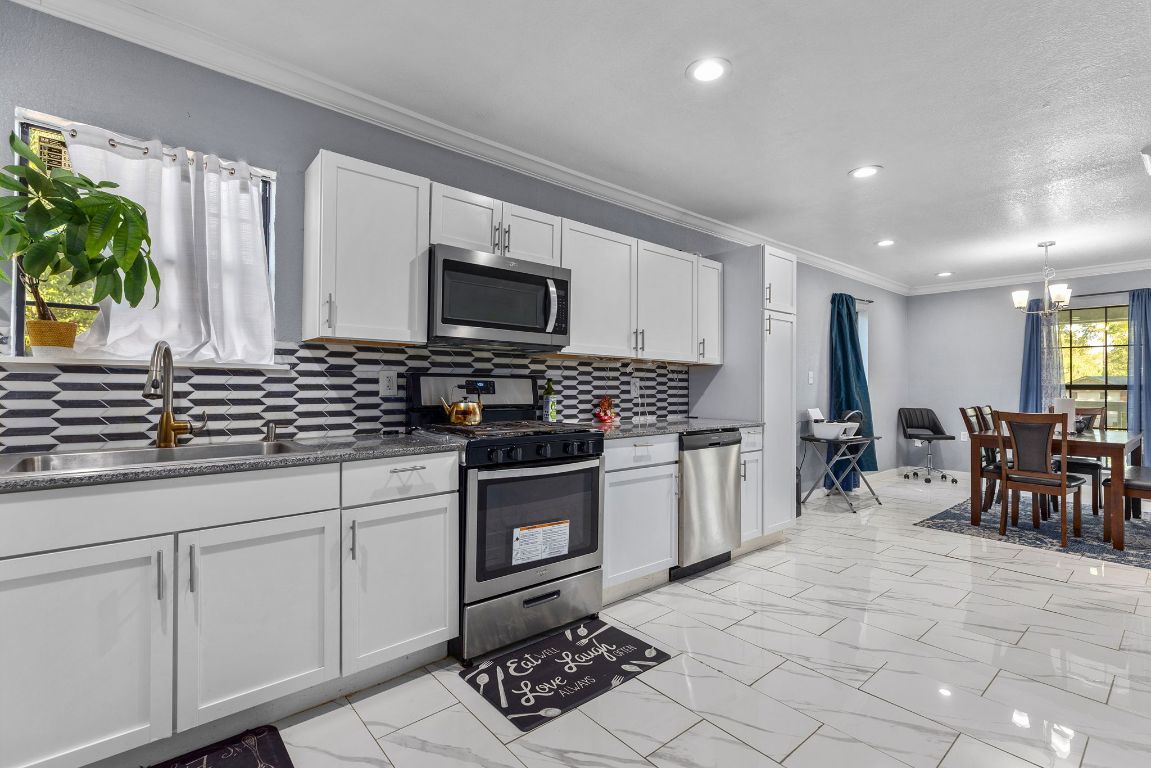 1110 South 9th Street Temple, TX 76504 - Photo 10 of 27 a kitchen with stainless steel appliances a sink stove and cabinets