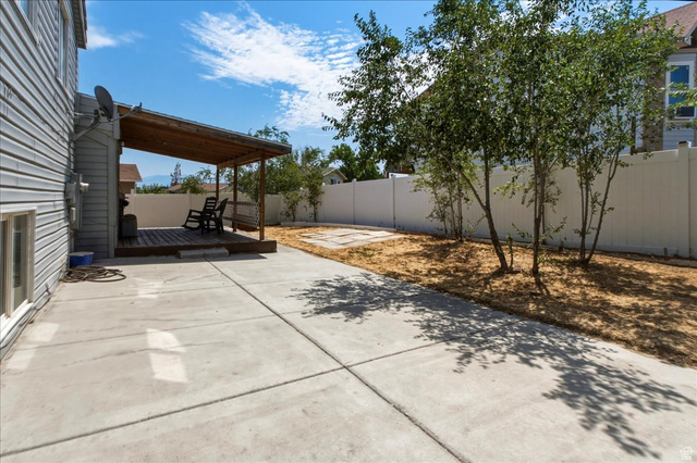 7989 Washington Road Magna, UT 84044 - Photo 26 of 30 Expansive concrete patio area featuring a covered wooden deck