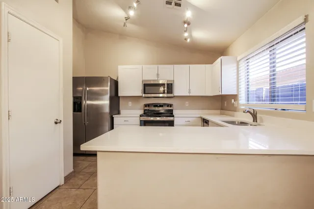 a kitchen with granite countertop a refrigerator and a sink