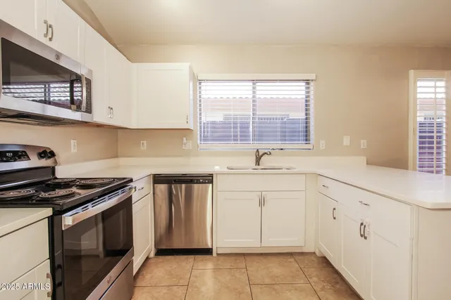 a kitchen with granite countertop white cabinets and white appliances