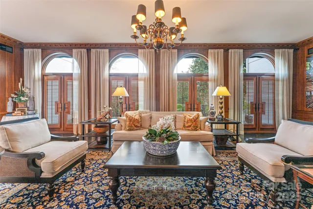 a living room with couches a table and a chandelier