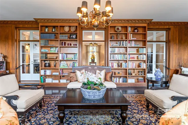 a living room with couches a table and a chandelier