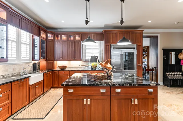 a kitchen with stainless steel appliances granite countertop a sink a stove and a wooden floors