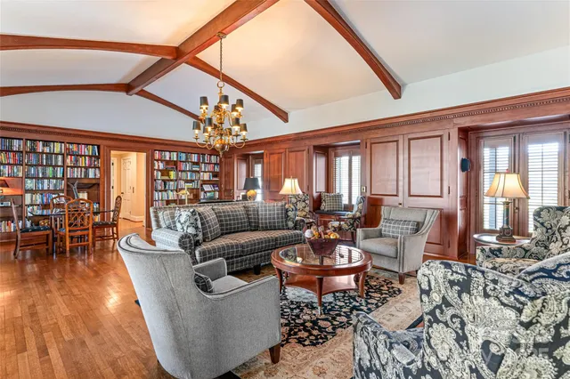 a living room with furniture a rug and a floor to ceiling window