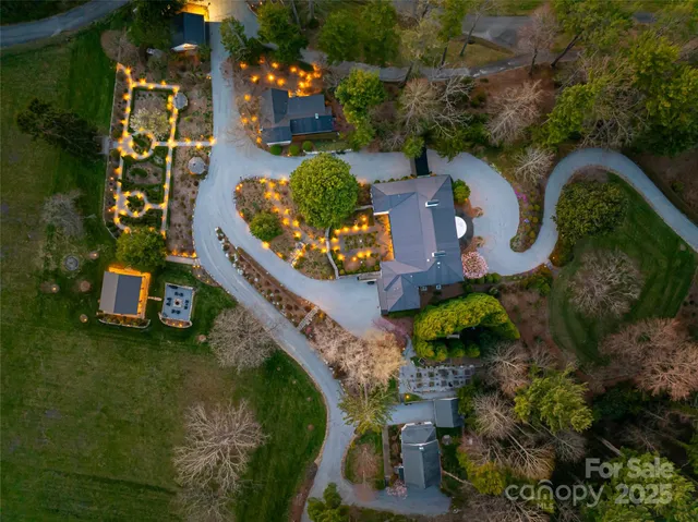 an aerial view of a house a yard and a fountain