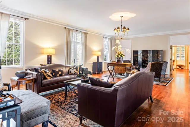 a living room with furniture chandelier and a large window