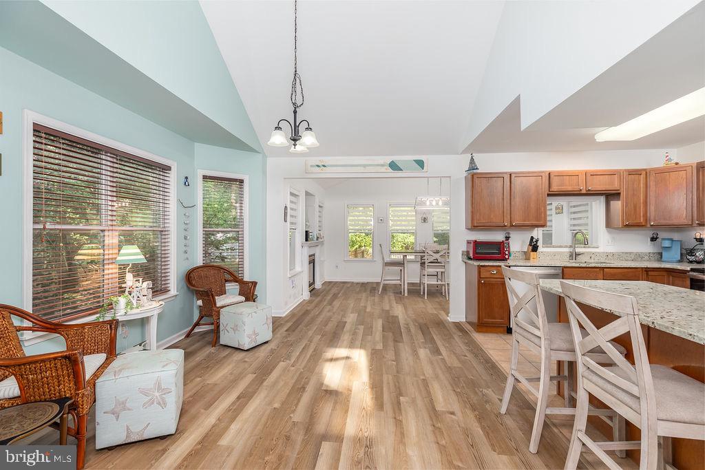 51 Martinique Circle Ocean Pines, MD 21811 - Photo 7 of 49 a open kitchen with granite countertop a refrigerator a sink dishwasher a dining table and chairs with wooden floor