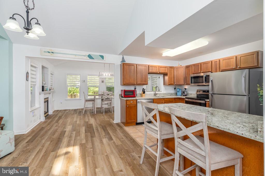 51 Martinique Circle Ocean Pines, MD 21811 - Photo 8 of 49 a kitchen with granite countertop a refrigerator a stove top oven a sink dishwasher and white cabinets with wooden floor