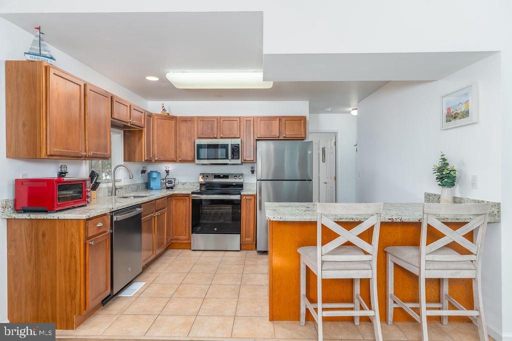 51 Martinique Circle Ocean Pines, MD 21811 - Photo 9 of 49 a kitchen with stainless steel appliances granite countertop a stove top oven a sink dishwasher and a refrigerator