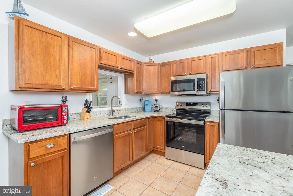 51 Martinique Circle Ocean Pines, MD 21811 - Photo 10 of 49 a kitchen with stainless steel appliances granite countertop a sink stove refrigerator and cabinets