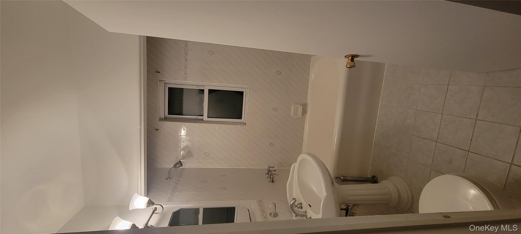 31-22 100th Street, Unit 2 Queens, NY 11369 - Photo 5 of 11 a bathroom with a sink a toilet and mirror
