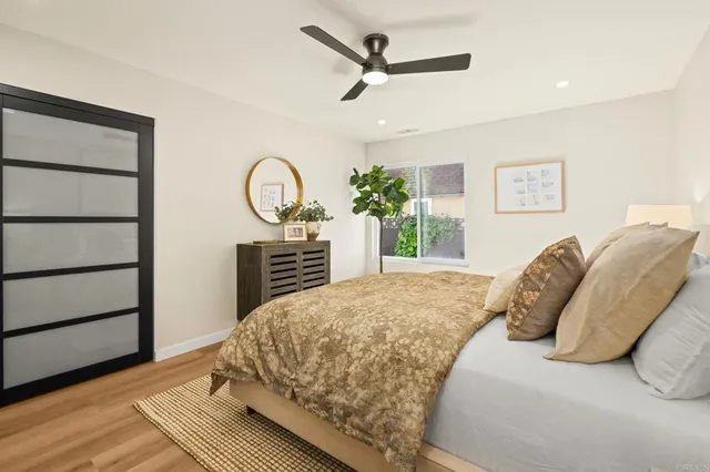 a bedroom with a bed a dresser and a potted plant