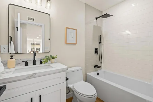 a bathroom with a granite countertop toilet a sink and a bathtub