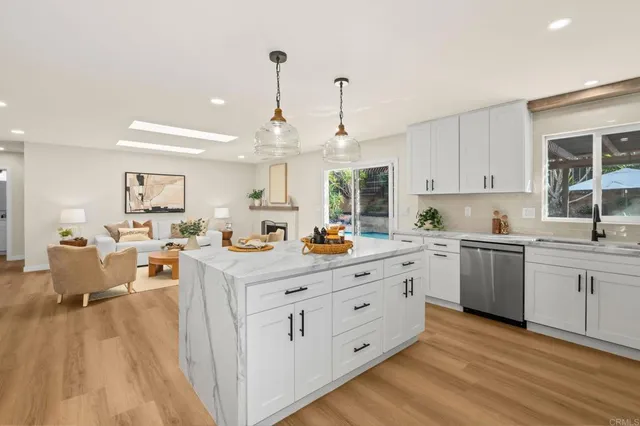 a kitchen that has a lot of cabinets in it with granite countertop a sink dishwasher and a wooden cabinets
