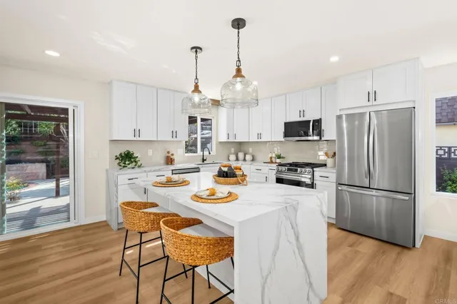 a kitchen with stainless steel appliances granite countertop a refrigerator a stove a sink dishwasher and a refrigerator with wooden floor