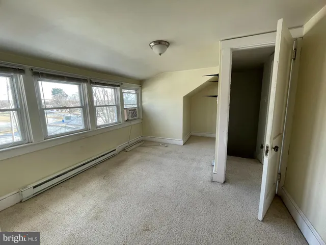 an empty room with windows and closet