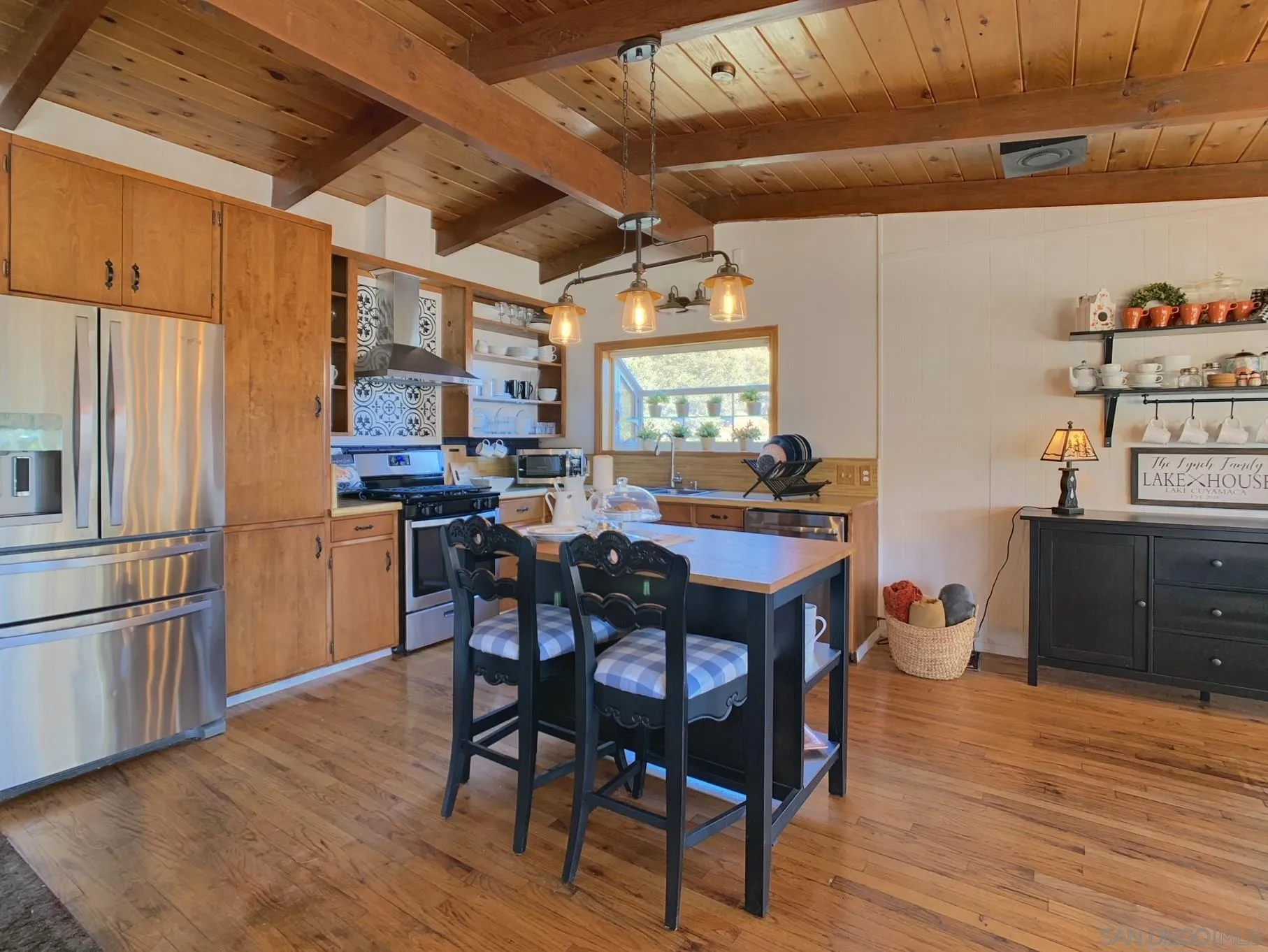 34642 Navajo Road Julian, CA 92036 - Photo 15 of 32 a kitchen with stainless steel appliances granite countertop a refrigerator a sink dishwasher a dining table and chairs with wooden floor