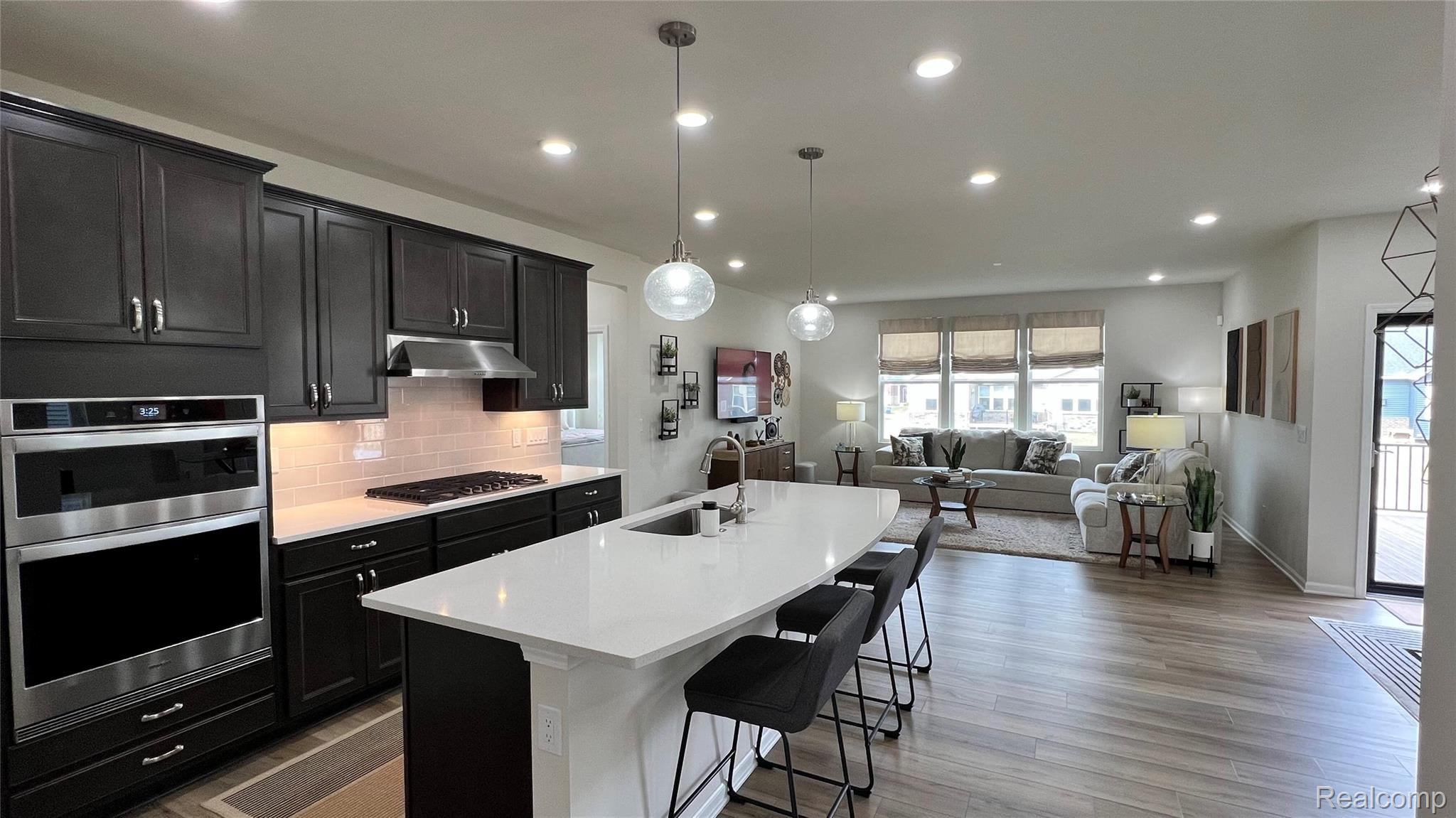 50192 Ogden Road Canton, MI 48188 - Photo 28 of 28 Kitchen featuring open floor plan, an island with sink, decorative backsplash, a breakfast bar area, and hanging light fixtures