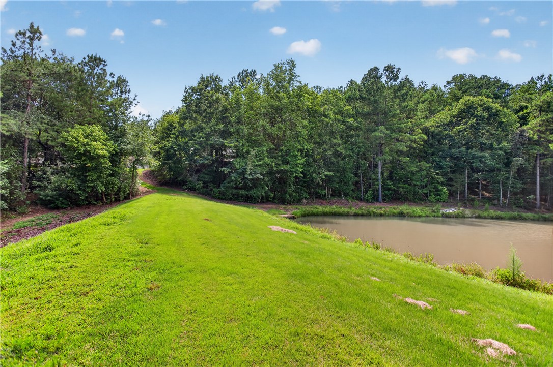 120 Coneross Knob Drive Seneca, SC 29678 - Photo 14 of 37 A lovely green dam, borders the serene pond, backed by a lush tree line under an open sky.