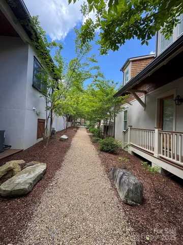 a backyard of a house with table and chairs plants