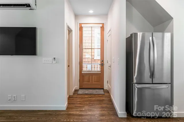 a view of kitchen with refrigerator and wooden floor