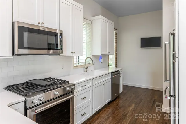 a kitchen with stainless steel appliances a sink a stove and microwave