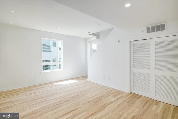 an empty room with wooden floor and windows