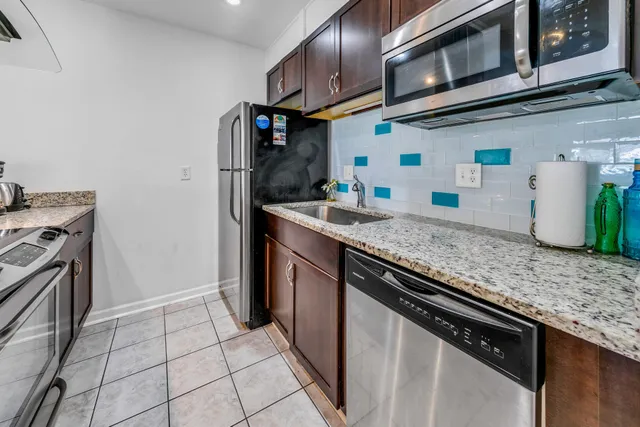 a kitchen with stainless steel appliances granite countertop a sink and stove