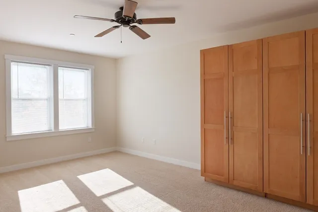 an empty room with windows and fan