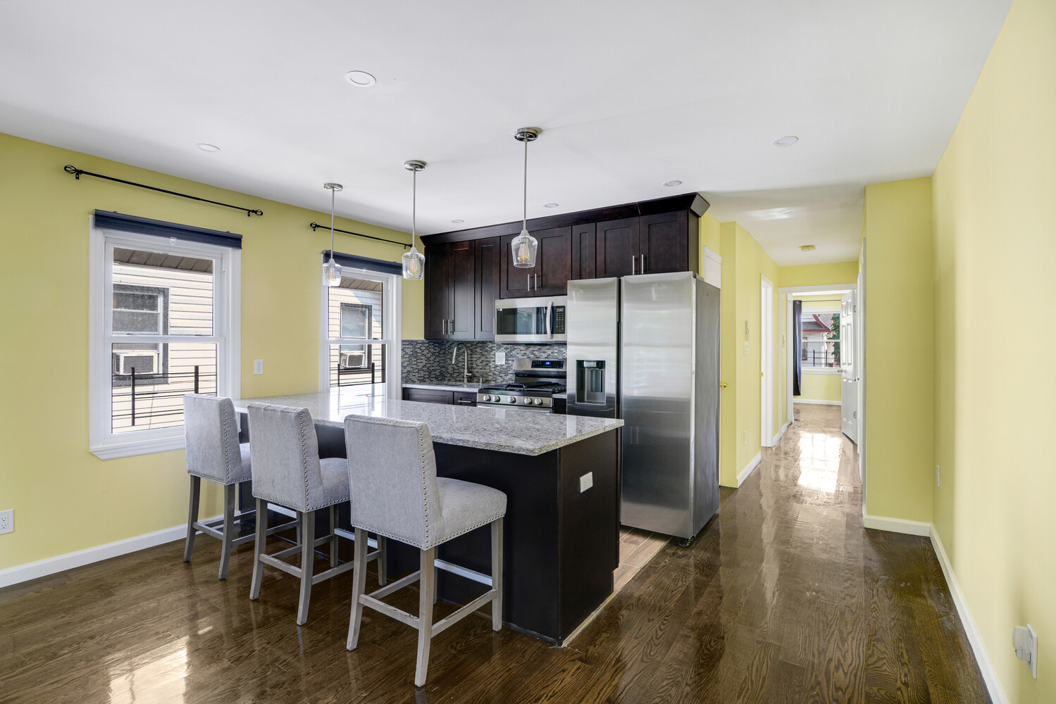 144-38 87th Avenue, Unit 2 Queens, NY 11435 - Photo 1 of 14 a kitchen with stainless steel appliances a dining table chairs refrigerator and sink