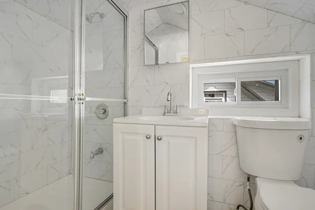 a bathroom with a sink a toilet and shower