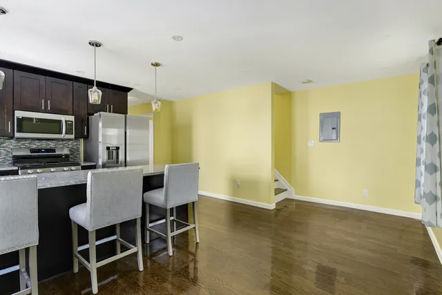 a dining room with stainless steel appliances kitchen island granite countertop a table and chairs