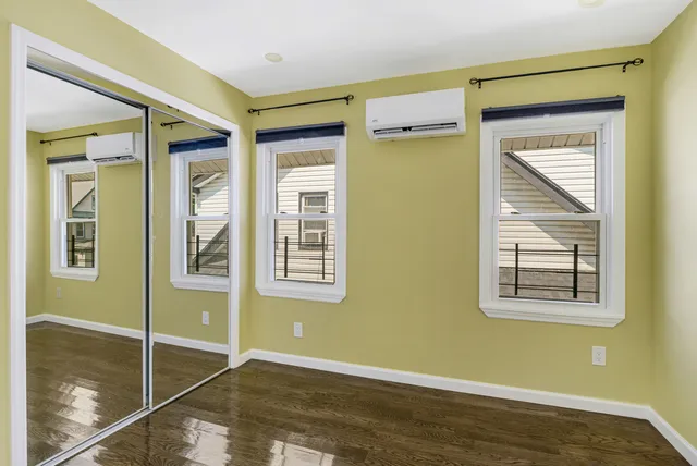 a view of an empty room with window and a bathroom