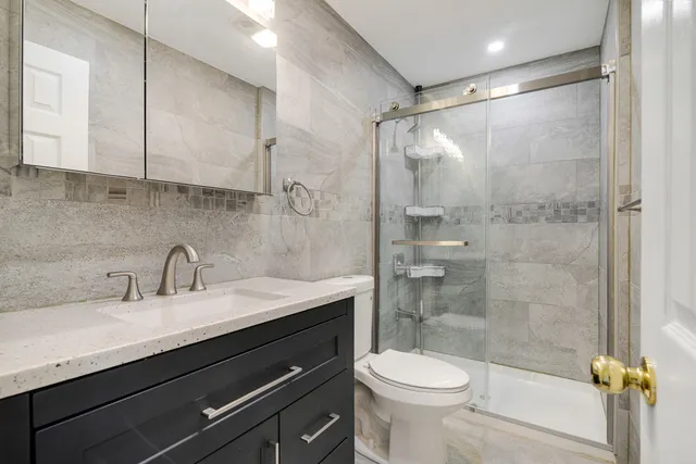 a bathroom with a sink a toilet and shower