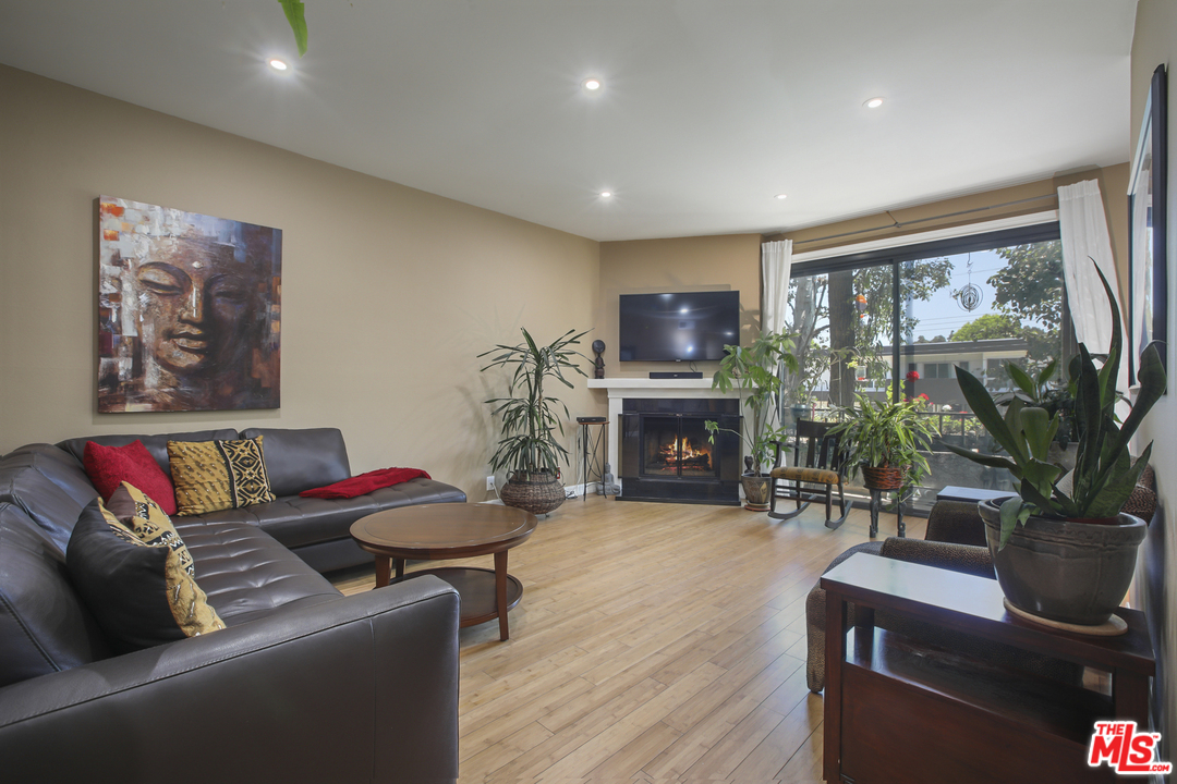 8110 Manitoba Street, Unit 104 Playa del Rey, CA 90293 - Photo 1 of 17 a living room with furniture a fireplace and a flat screen tv