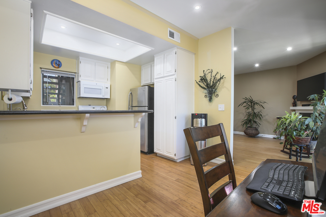 8110 Manitoba Street, Unit 104 Playa del Rey, CA 90293 - Photo 4 of 17 a living room with furniture wooden floor and a refrigerator