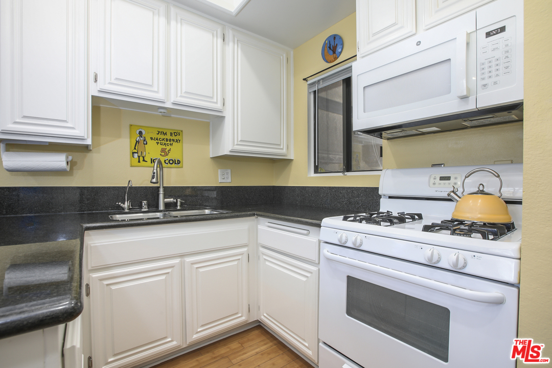 8110 Manitoba Street, Unit 104 Playa del Rey, CA 90293 - Photo 5 of 17 a kitchen with stainless steel appliances granite countertop a sink stove and cabinets