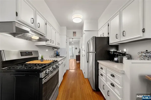 a kitchen with stainless steel appliances a stove refrigerator sink and cabinets