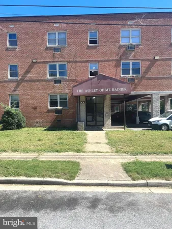 a view of a brick building next to a yard