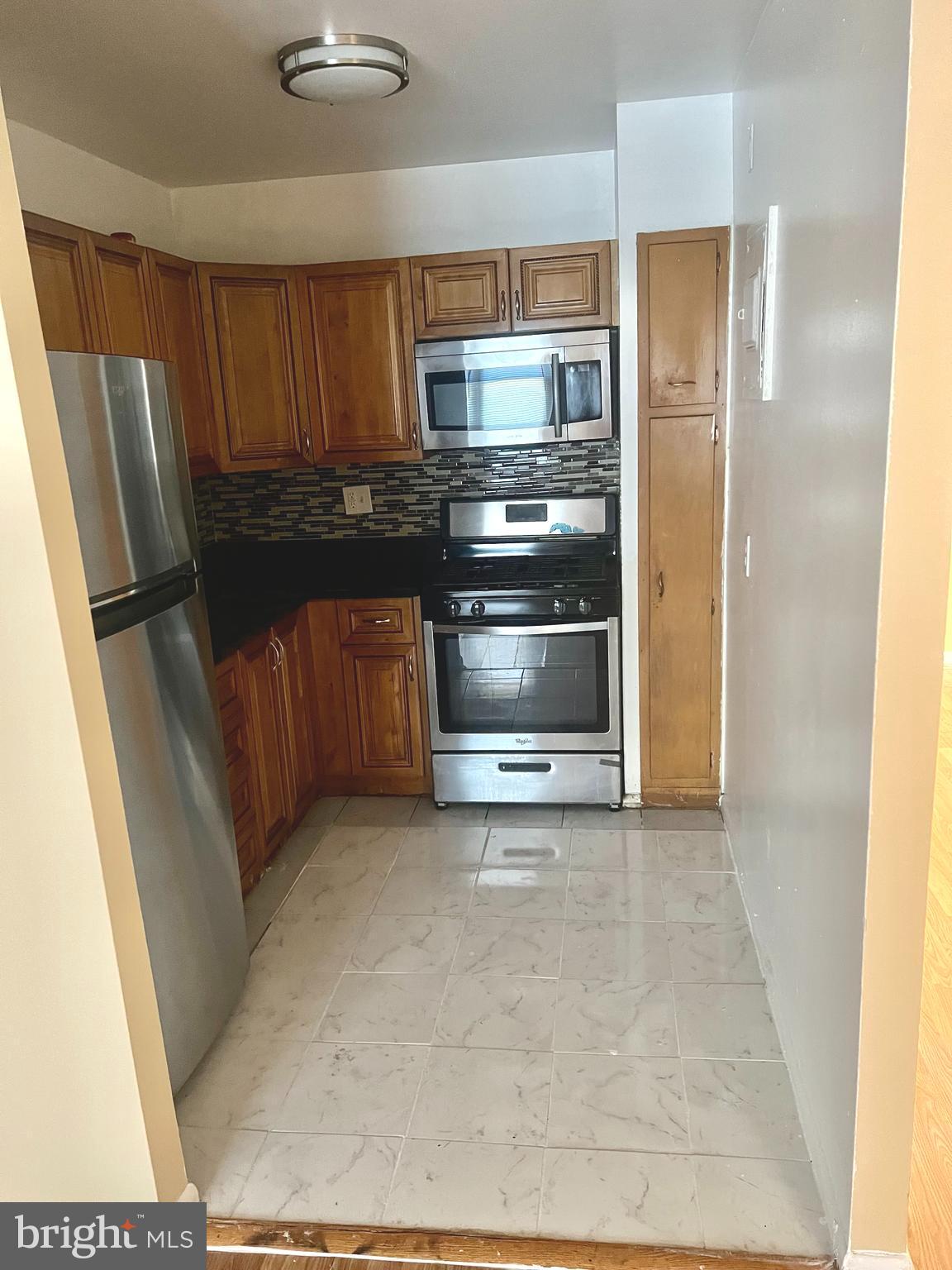 4001 29th Street, Unit 202 Mount Rainier, MD 20712 - Photo 2 of 7 a kitchen with granite countertop a refrigerator and a sink