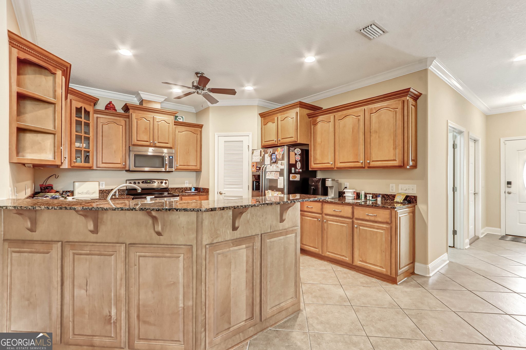601 Eagle Boulevard Kingsland, GA 31548 - Photo 9 of 41 a kitchen with stainless steel appliances granite countertop a stove top oven a sink a refrigerator and white cabinets