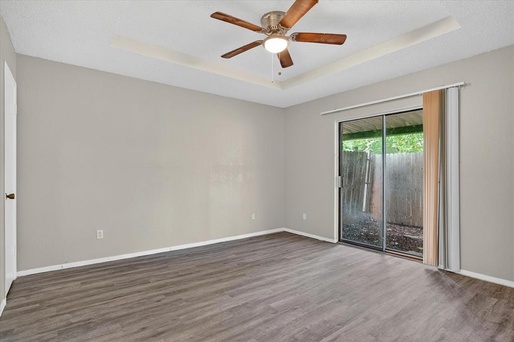 119 Del Rio Avenue, Unit C Benbrook, TX 76126 - Photo 12 of 17 an empty room with wooden floor and windows