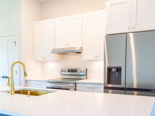 a kitchen with granite countertop a refrigerator and a sink