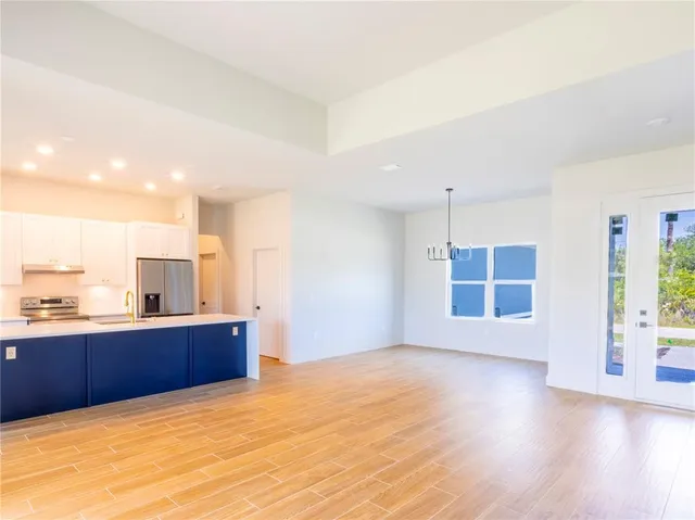 a view of an empty room with window and wooden floor