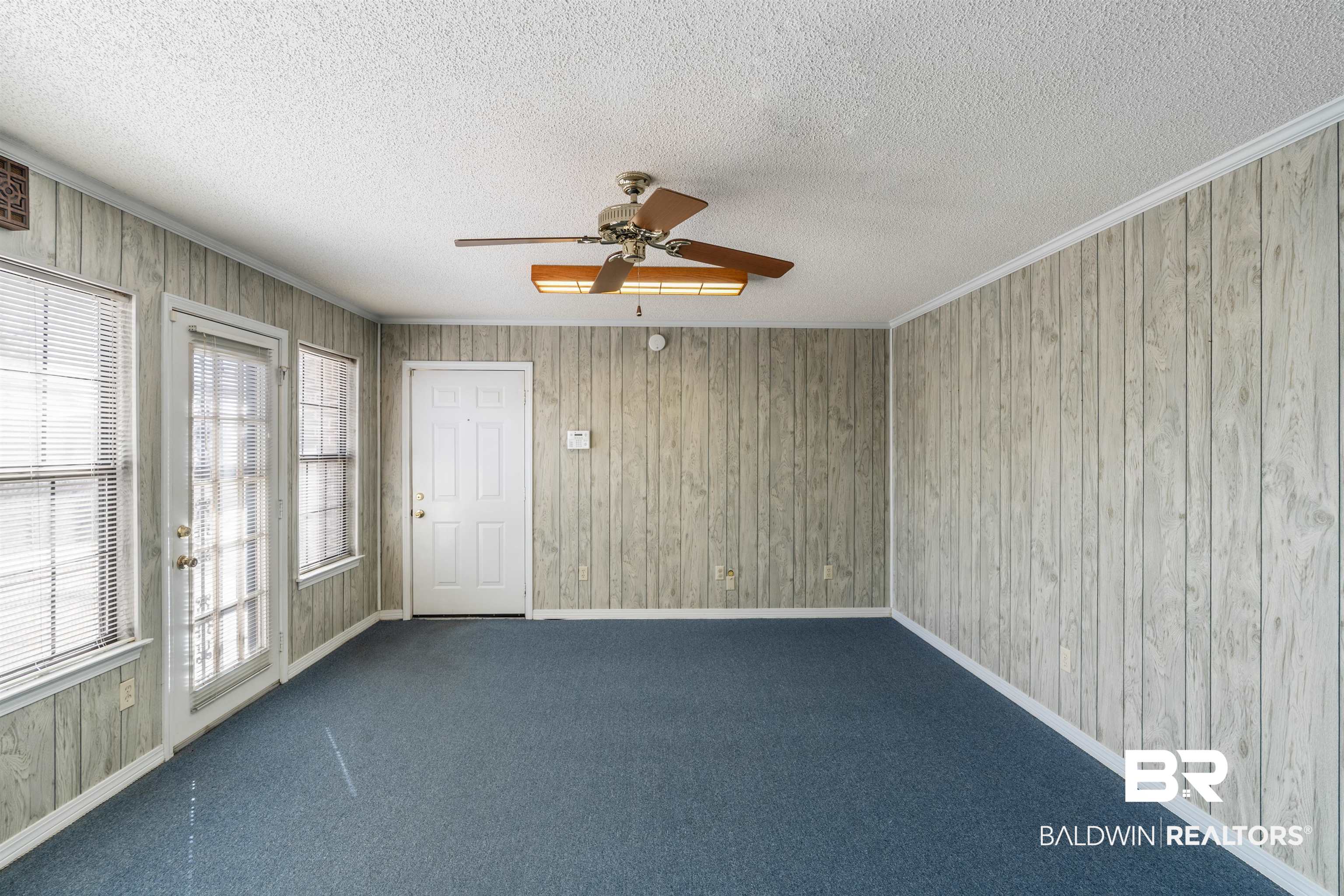 9751 Pine Knoll Road Mobile, AL 36608 - Photo 13 of 36 Spare room with ceiling fan, wooden walls, carpet, and a textured ceiling