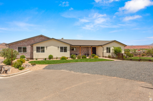 2591 East Washington Dam Road Washington, UT 84780 - Photo 2 of 67 Contemporary residence featuring a brick and stucco exterior, a covered entryway, and a low-pitched roofline