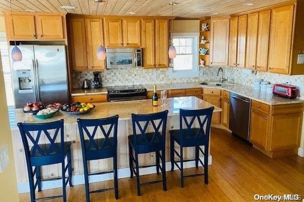 a kitchen with stainless steel appliances granite countertop a table chairs and a sink